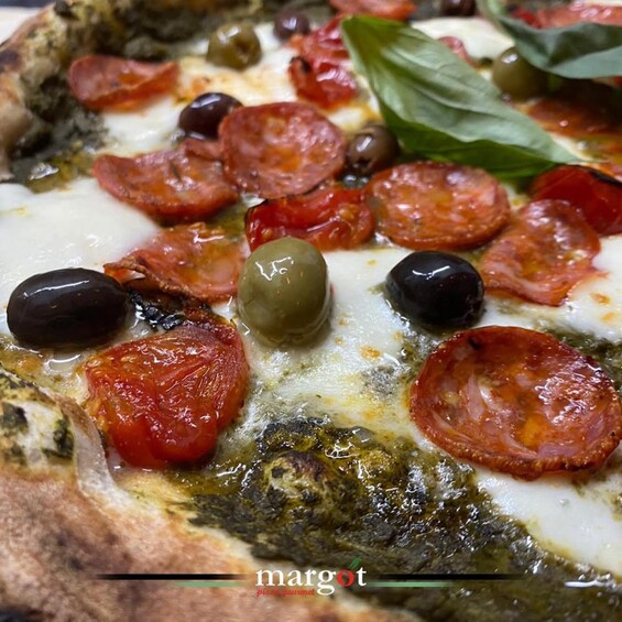 A close-up of a pizza with pepperoni, tomatoes, and olives. 3