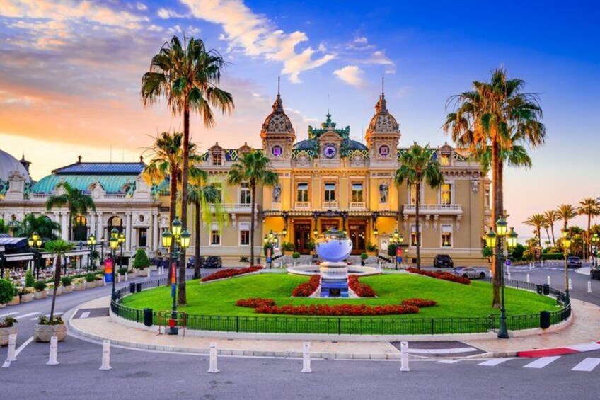 A grand building with domes and spires, surrounded by a well-manicured lawn and palm trees. 2