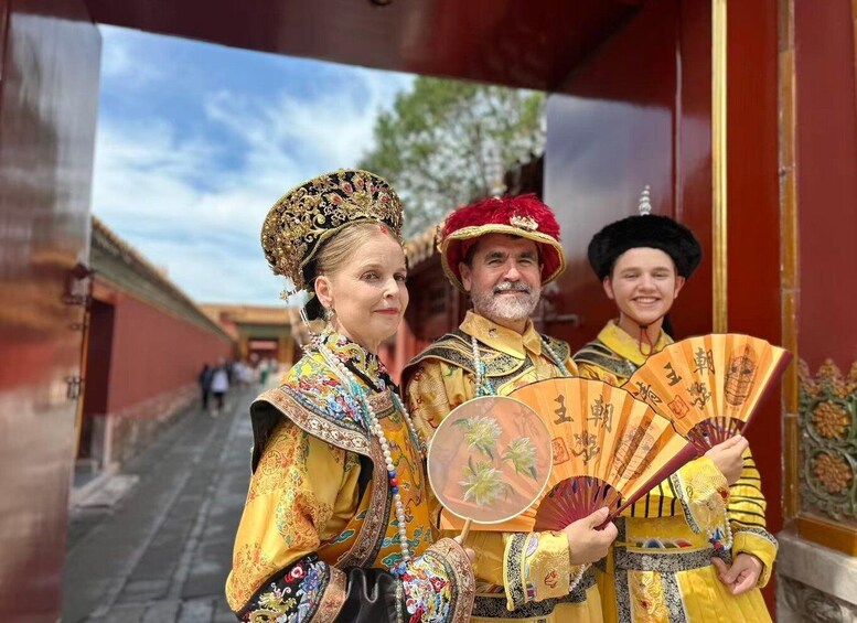 A group of people in traditional attire, holding fans with Chinese characters. 1