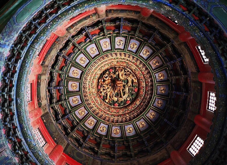 A circular stained glass window with intricate designs and a central figure. 3