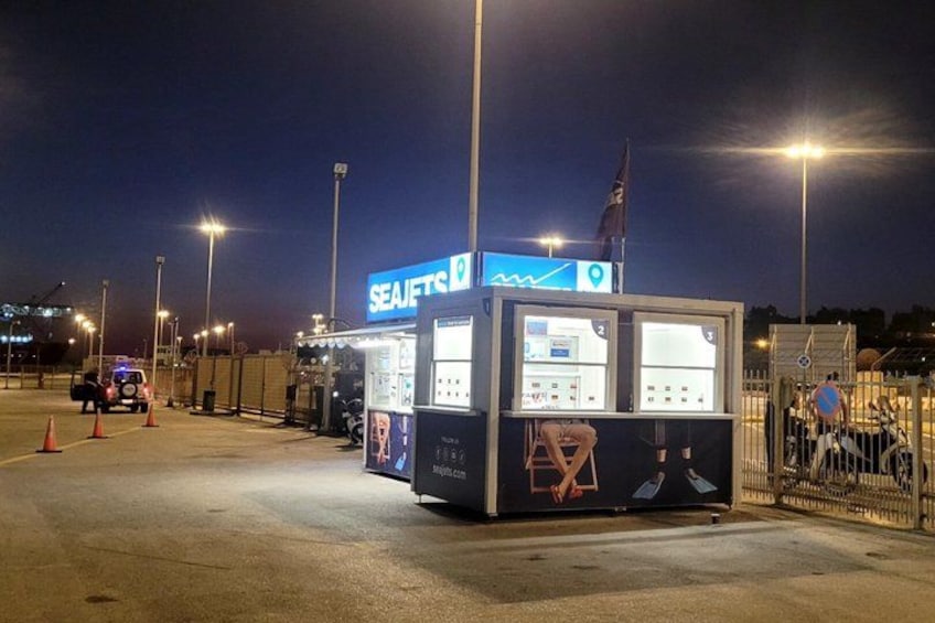 A SEAFITS kiosk at night with illuminated signage, a flag, and a fenced area. 2