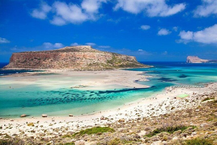 A coastal landscape with clear turquoise waters, sandy beaches, and rocky cliffs. 4