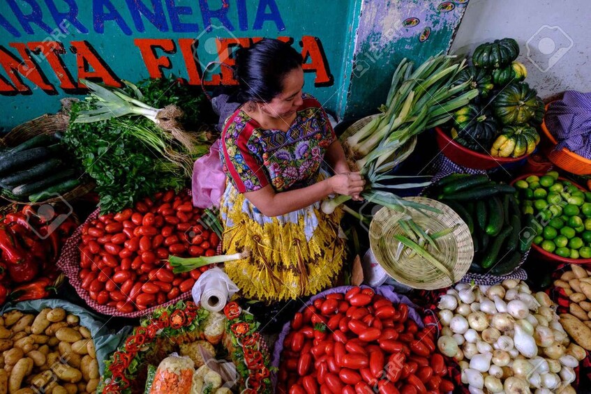 A market stall with various vegetables like tomatoes, cucumbers, and peppers. 3