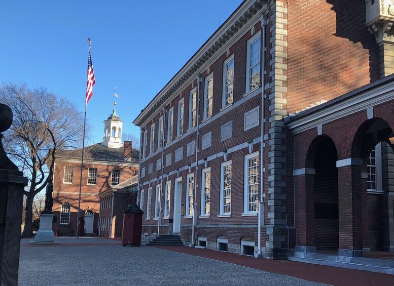 A historic brick building with arched windows and a flagpole with an American flag. 4