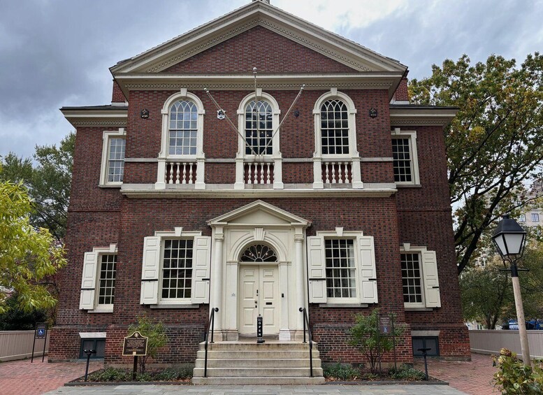 A red brick building with white shutters and a central entrance. 2