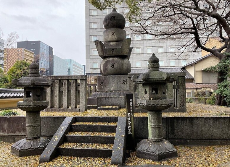 A traditional Japanese stone lantern and a pagoda-like structure in a park with steps leading up to them. 3