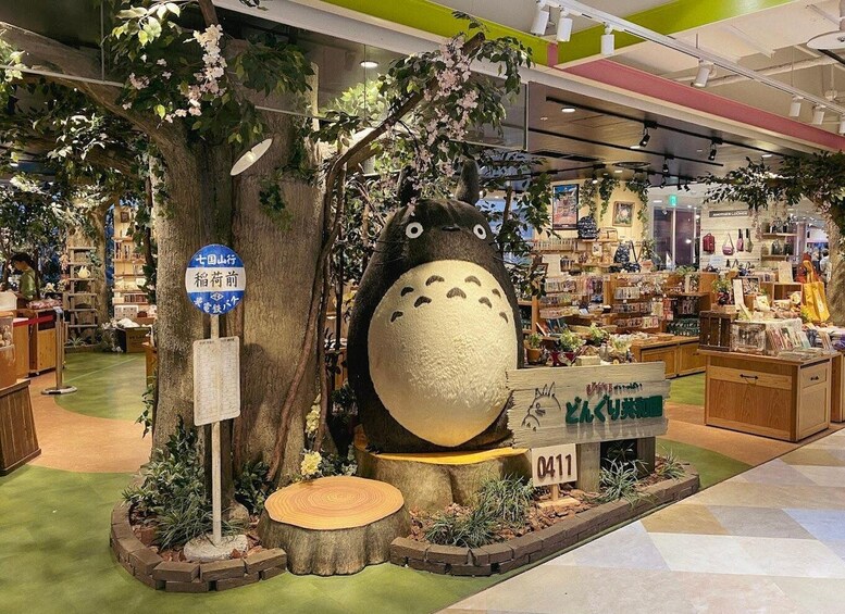A store with a large tree and a plush toy. There are signs and a display counter. 2