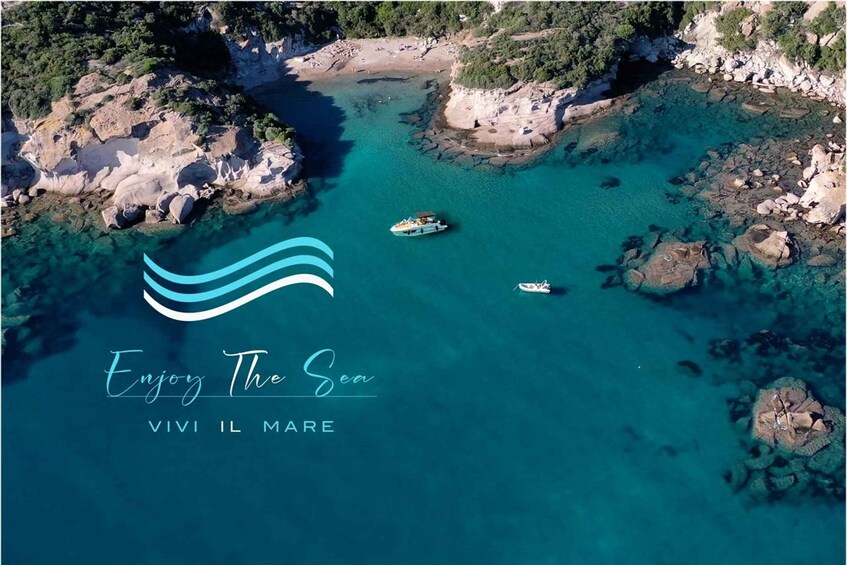 An aerial view of a coastal area with clear turquoise waters, rocky shores, and a boat. 1
