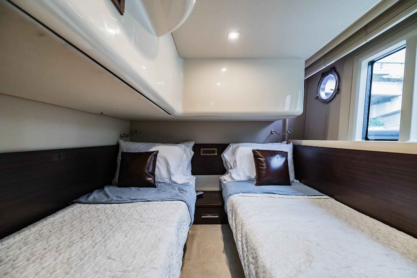 A compact cabin with two beds, a small window, and a ceiling light. 2