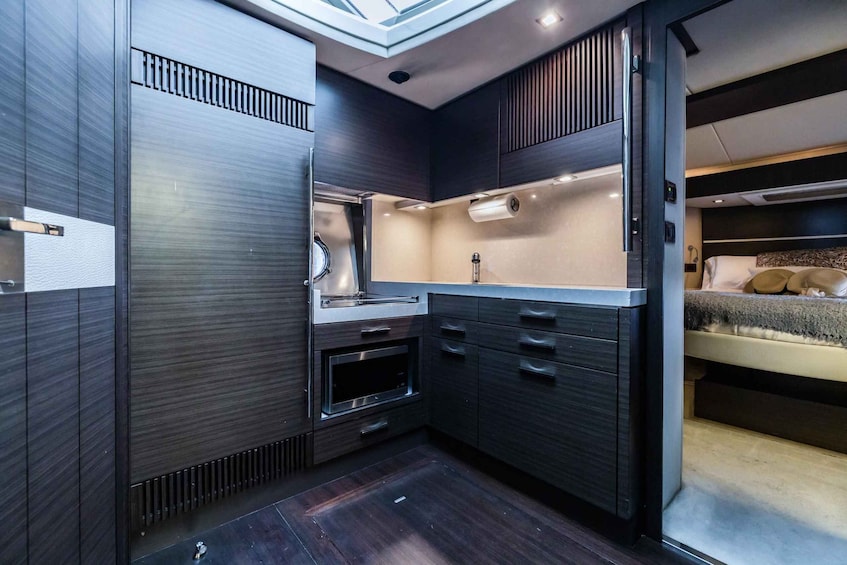 A modern kitchen with dark wood cabinets, a built-in oven, and a countertop. 3