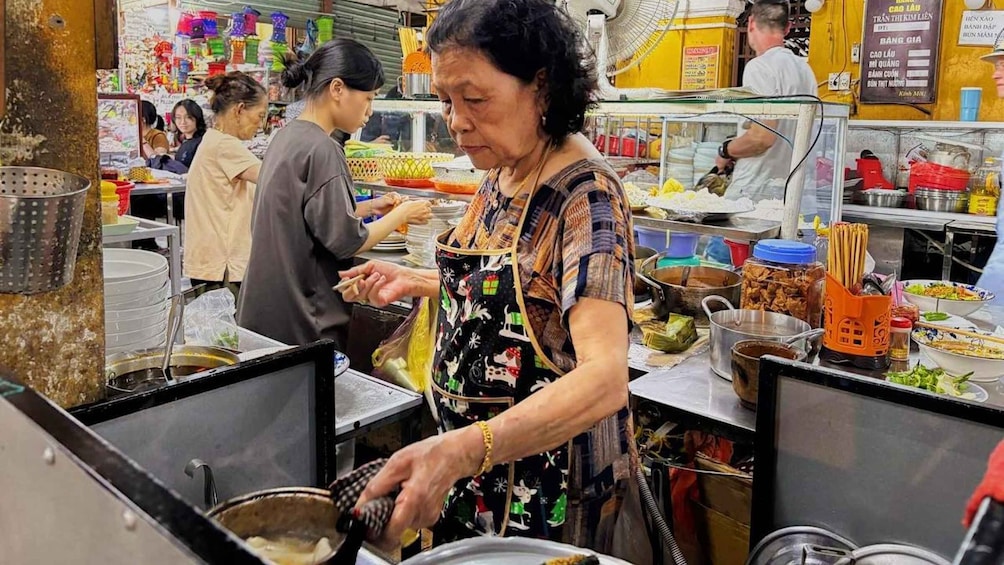 A bustling food stall with a cook preparing food, surrounded by various cooking utensils and ingredients. 3