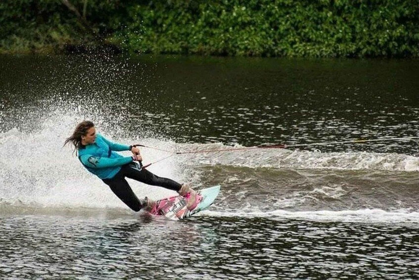 A person wakeboarding on a body of water with splashes around them. 3