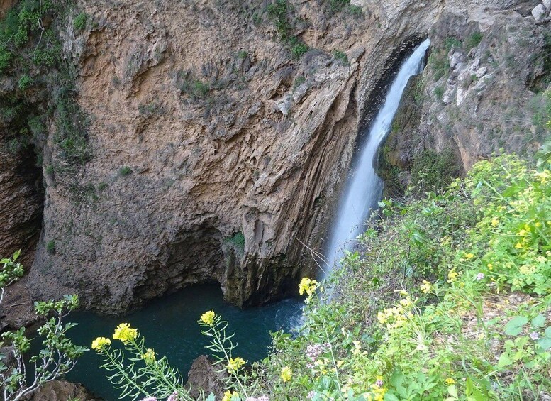 A waterfall cascading down a rocky cliff into a pool below. 5