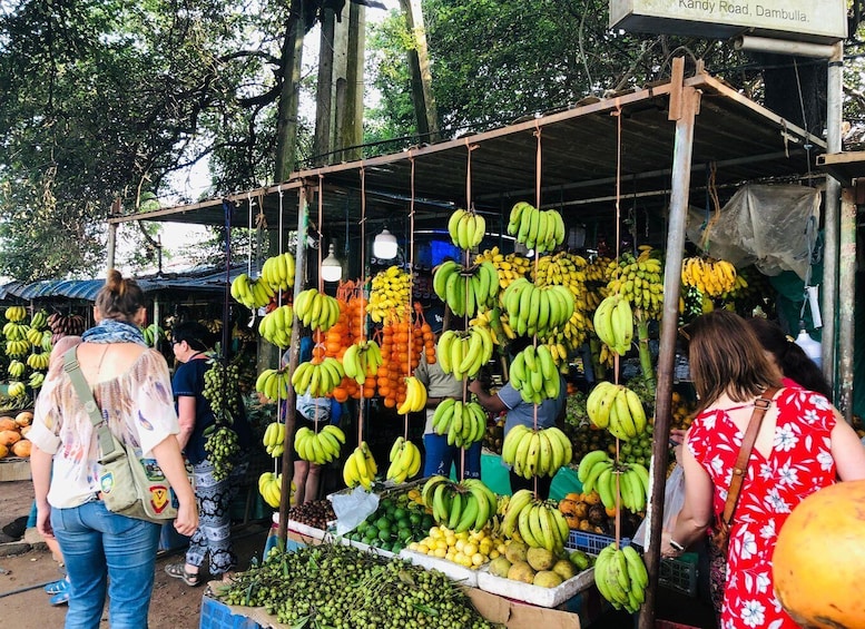 A market stall with various fruits like bananas and oranges. 1