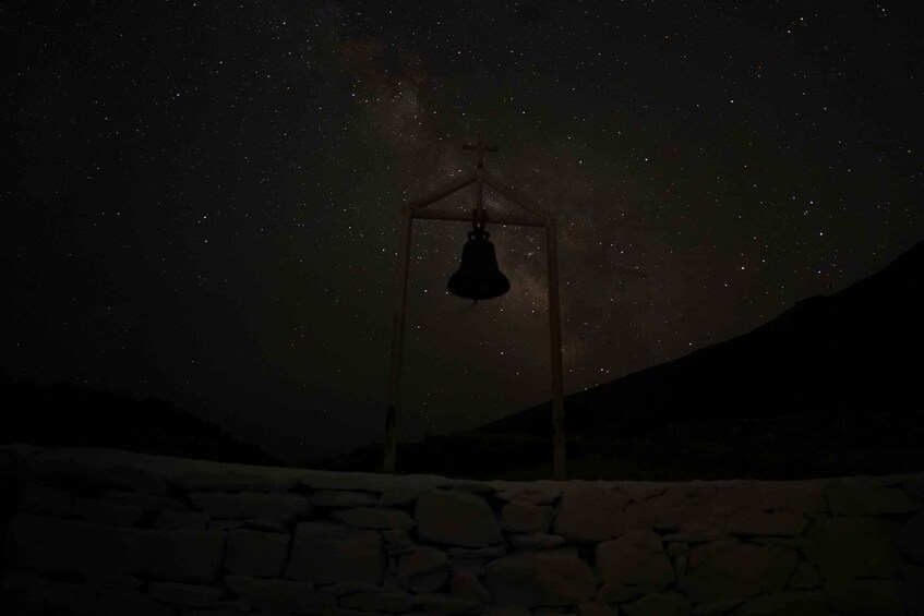 A stone wall and a bell tower against a starry night sky. 3