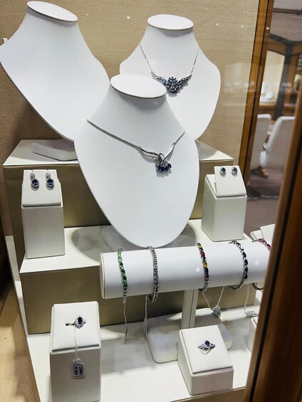 Jewelry displays including necklaces, bracelets, and earrings on white mannequins. 4