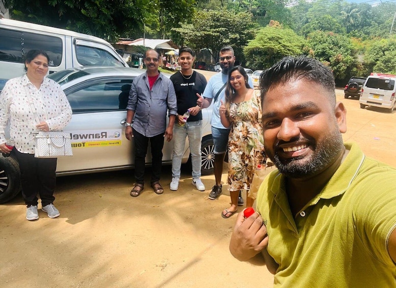 A group of people standing in front of a white van with a logo and text on it. 5