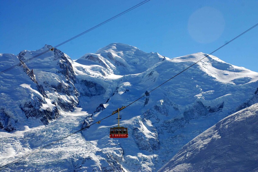 A cable car labeled "Brevent" ascending a snow-covered mountain. 4