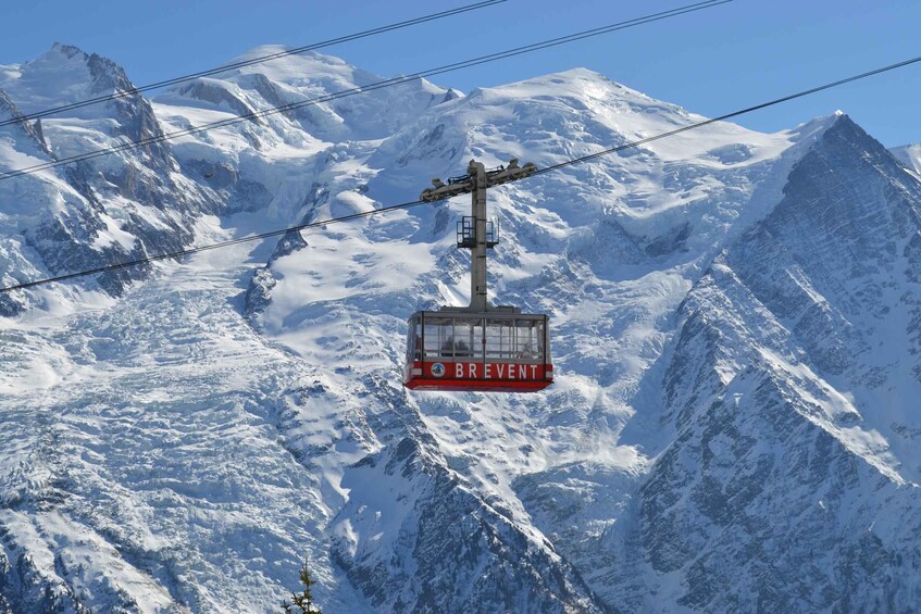 A cable car labeled "BREVENT" suspended between mountains. 5