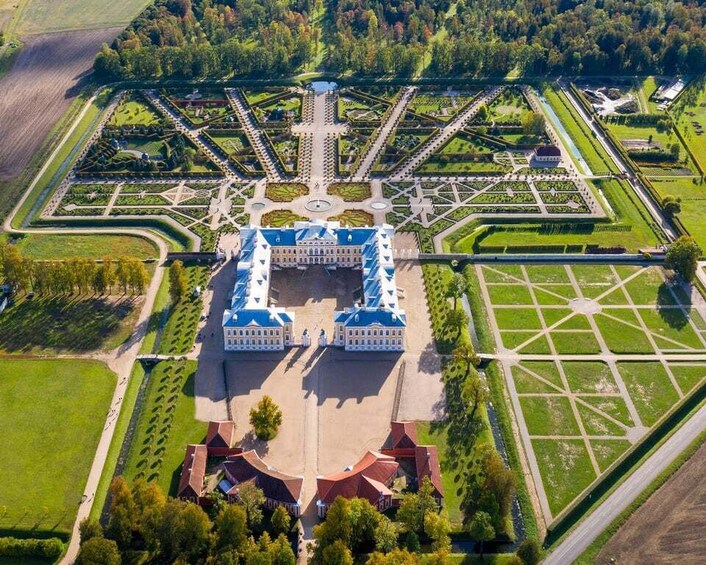 An aerial view of a grand palace with symmetrical gardens and a central fountain. 5