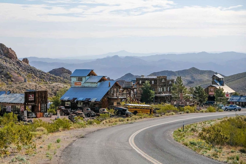 A desert town with historic buildings, a winding road, and mountains in the background. 3