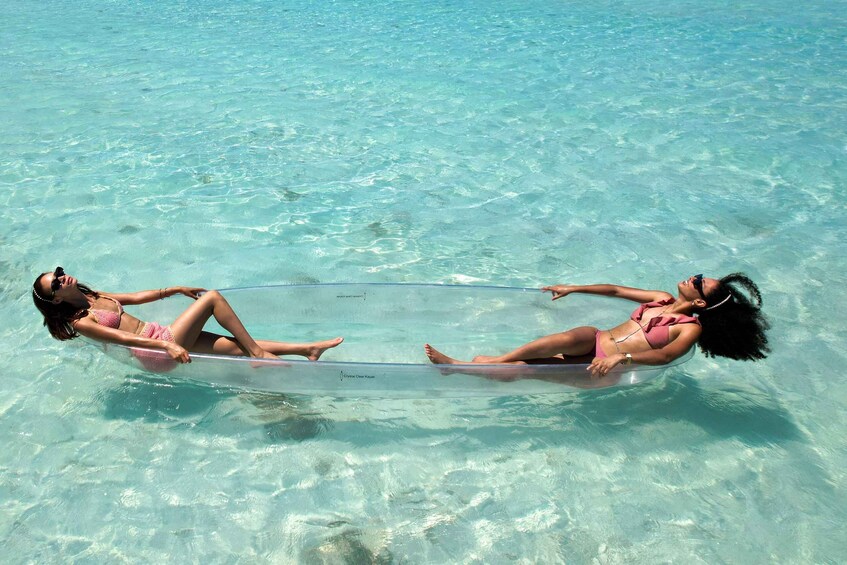 Two people floating on a clear water surface in a tropical setting. 2