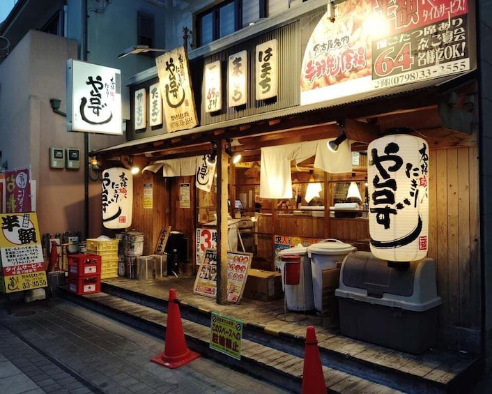 Un restaurant dont l’enseigne est en japonais et dont la façade est en bois. 1