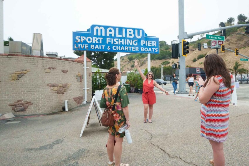 A sign for Malibu Sport Fishing Pier with a live bait and charter boats. 1