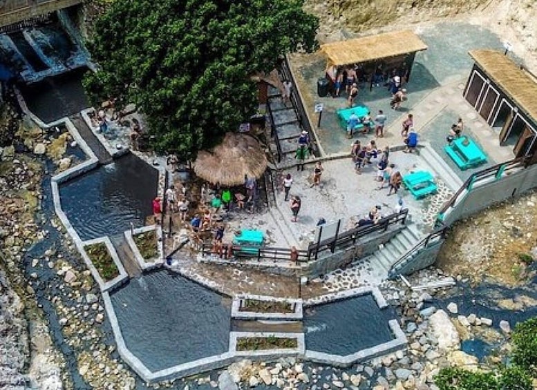 A hot spring area with multiple pools and people relaxing. 4