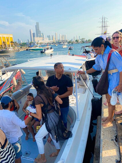 A group of people on a boat near a city skyline with tall buildings. 3