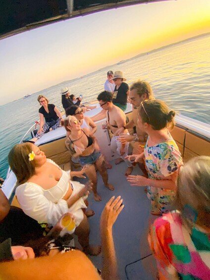 A group of people on a boat at sunset. 1