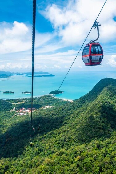 A cable car ascending a mountain with a view of a coastal area below. 2