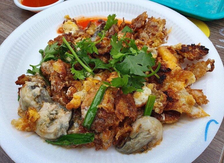 A plate of fried food with vegetables and garnished with cilantro. 5