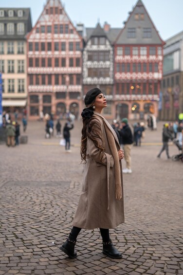 A person walking on cobblestone pavement in a historic European town square. 4