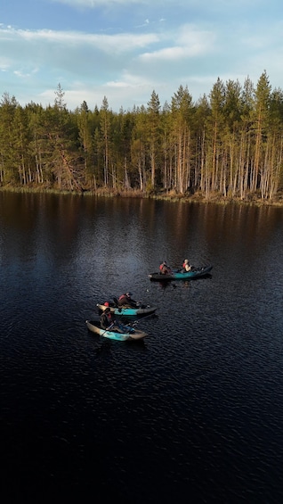 Three kayaks on a calm lake surrounded by a forest. 3