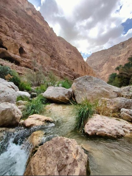 A rocky canyon with a stream flowing through it. 4
