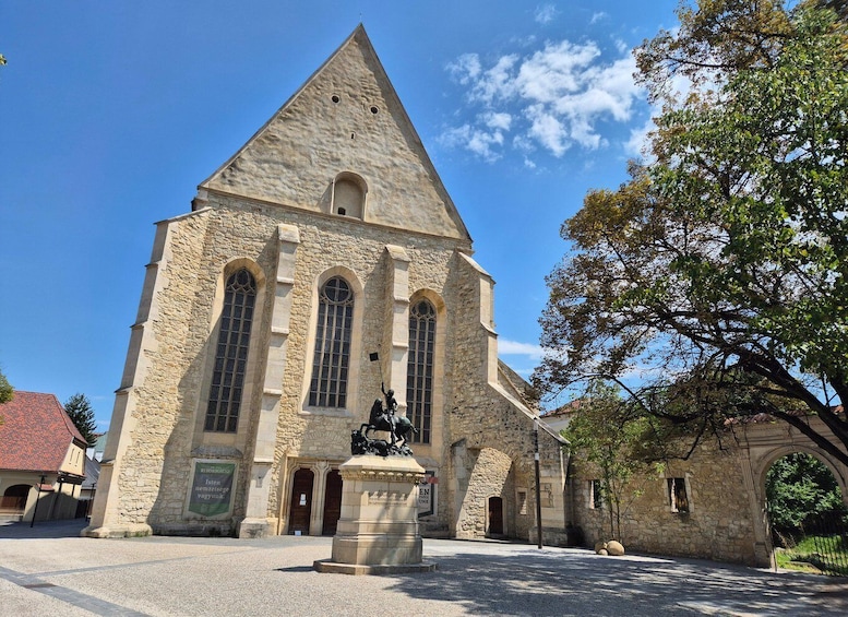 A stone church with a tall triangular roof and three arched windows. 1