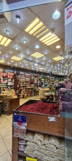 A well-lit store with various packaged goods on shelves and a display of dried fruits and nuts. 4