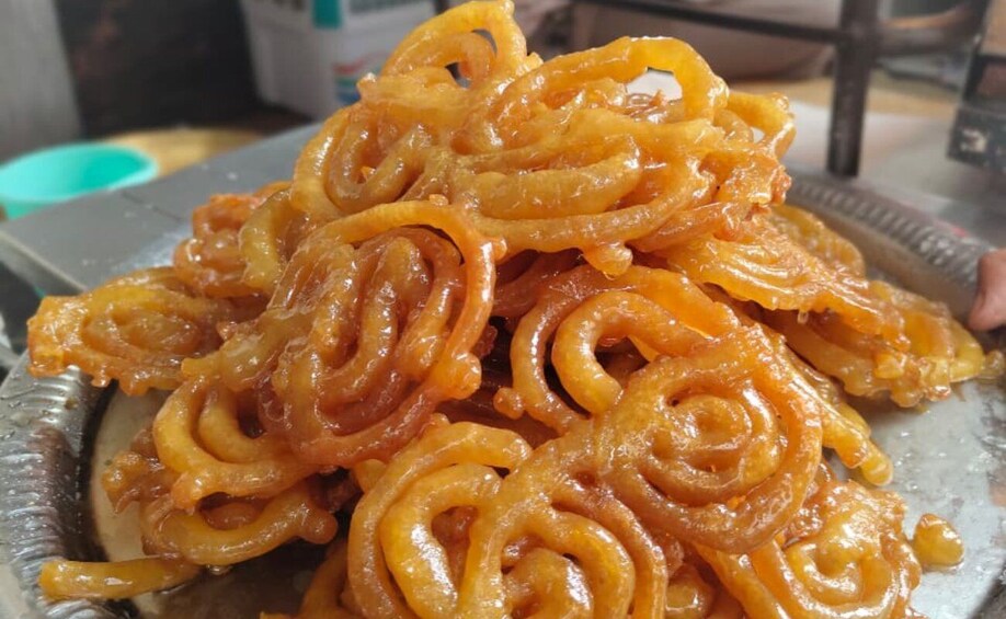 A plate of spiral-shaped, golden-brown sweets. 4