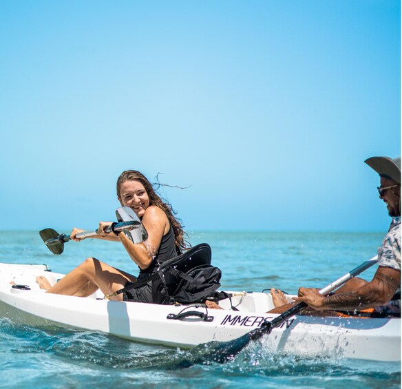 Two people in a small white boat on the water. 5