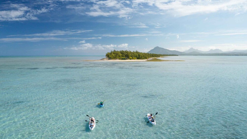 Kayakers on a clear turquoise sea with a small island in the background. 4