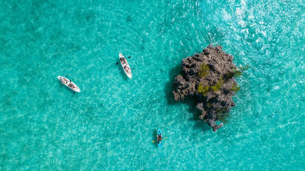 Kayaks on turquoise water with a rocky island. 2