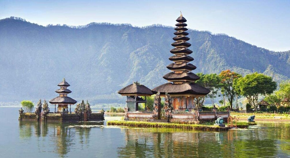 A serene lake with traditional pagodas and a mountain backdrop. 5