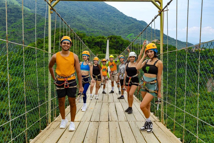 A group of people on a suspension bridge with a mountainous landscape in the background. 5