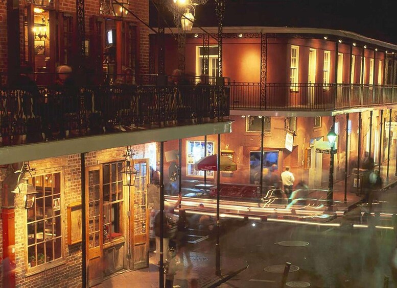A nighttime street scene with a brightly lit building, a street lamp, and a pedestrian crossing. 5
