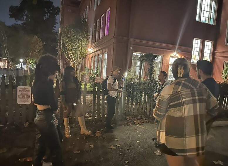A group of people standing outside a building at night. 3