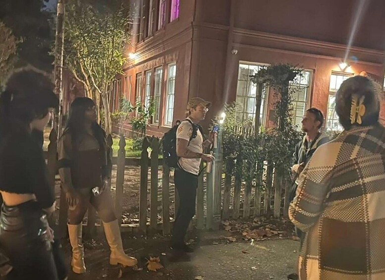 A group of people standing outside a building at night. 4