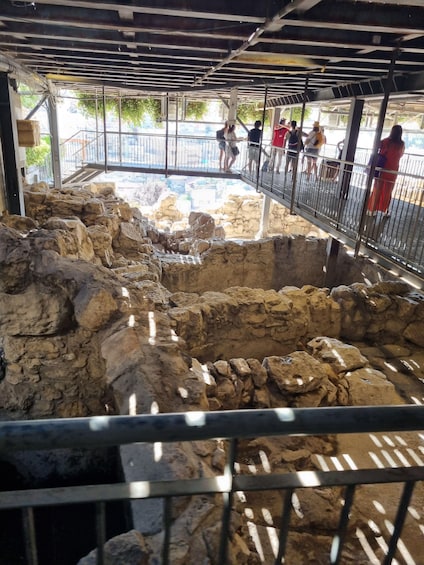 An archaeological excavation site with exposed soil and stone structures. 2