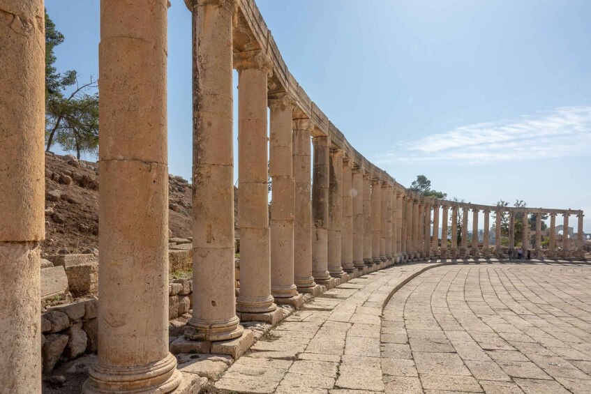 Ancient stone columns lining a paved walkway. 2