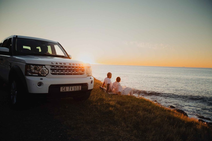 A white Land Rover with a license plate CA 79K 11 8 parked by the water. 1